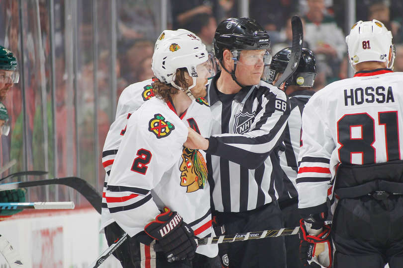 Duncan Keith is escorted off the ice after high sticking Wilds Charlie Coyle (Photo by Bruce Kluckhohn)
