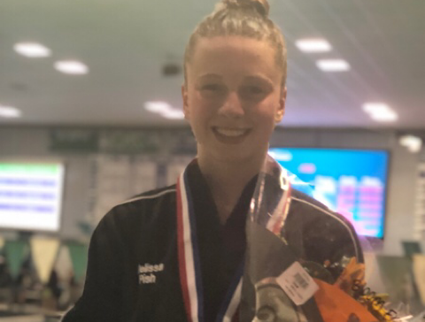 Melissa Pish stands on block one after placing first in the 500 freestyle. 