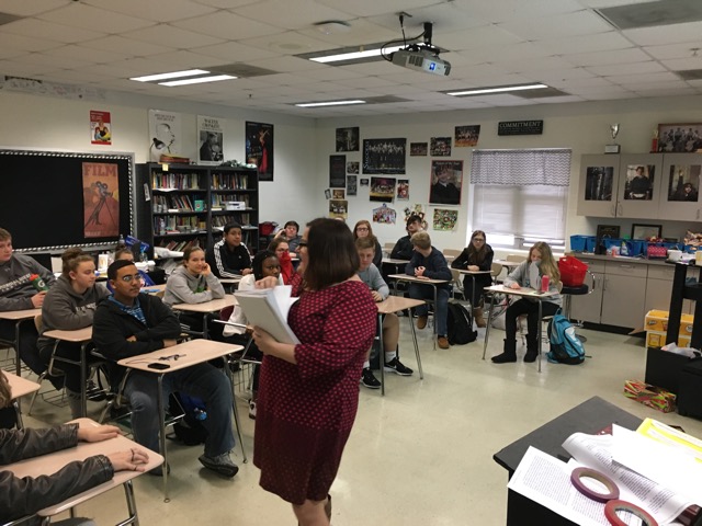 Ms. Marvin is seen passing out a syllabus to her English II class as the new semester begins.
