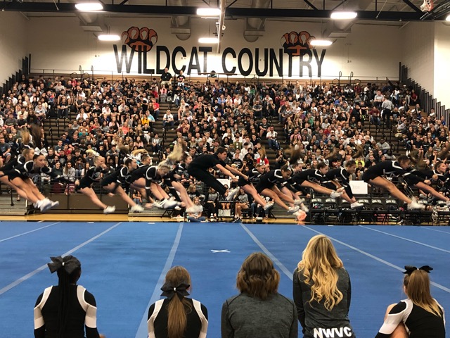The varsity cheer team starts off their performance at the Homecoming assembly