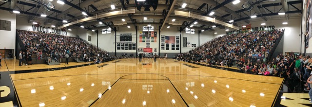 A panoramic shot of the North Gym filled with students and staff during the assembly. 