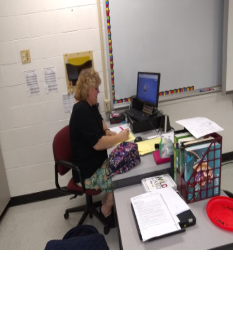 Mrs. Saal grading papers during her lunch period.  