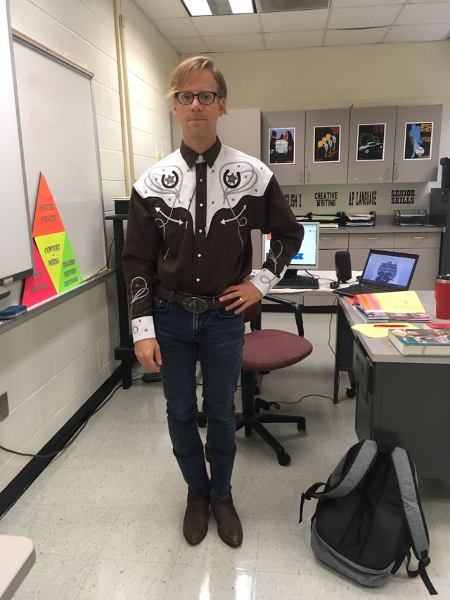 Showing true cowboy-ism, Jeffrey Beal, one of Normal Wests English teachers, dresses in farm work boots, a belt and belt buckle, and a fanciful cowboy shirt.