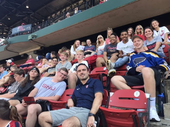 Normal West marketing students, teacher Mrs.Maynerish, and volunteers pose for a celebratory photo after the Cardinals hit their first of three home runs that day. 