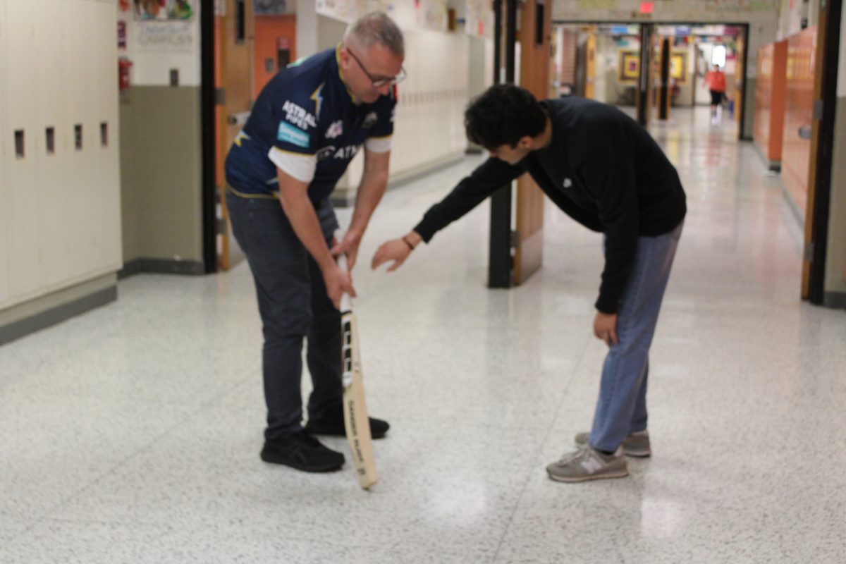 In his free time, Vrajesh Patel (12) teaches Dr. Bierbaum about cricket in preparation for the ICC Mens T20 World Cup. 