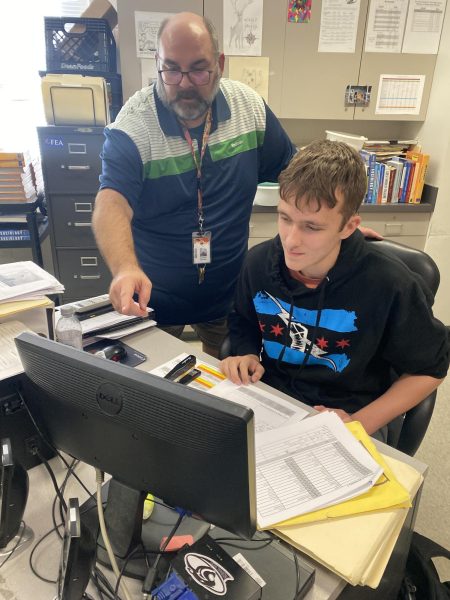 Veteran social studies teacher, Anthony Berardi not only helps students get registered to vote, but he also helps facilitate a mock election held the Friday before election day during each election cycle. Above, Berardi assists Senior Owen Voorheis to make sure he is ready and registered to cast his vote on November 5.