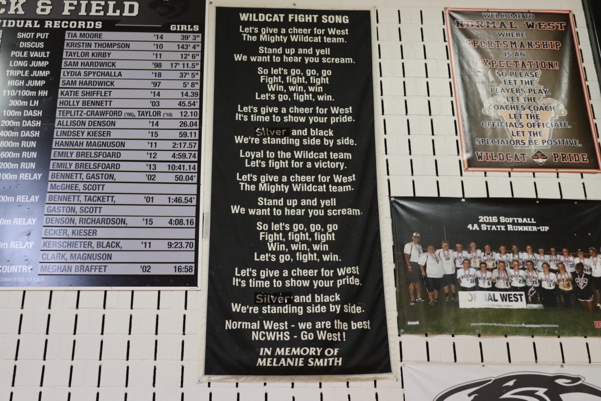 The Wildcat Fight Song banner is on the wall in the North Gym, showing the infamous song's lyrics. The banner is dedicated to Melanie Smith, a cheerleader who passed away on August 3,  1997.
