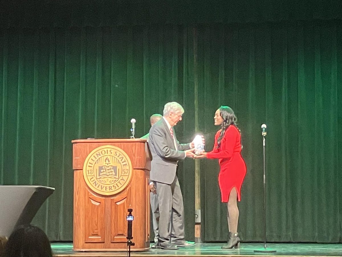 Senior Benedicte Diamonika was recently awarded the Dr. Martin Luther King Jr. Award. Above, Diamonika accepts the award from Chris Koos, the may of the town of Normal.