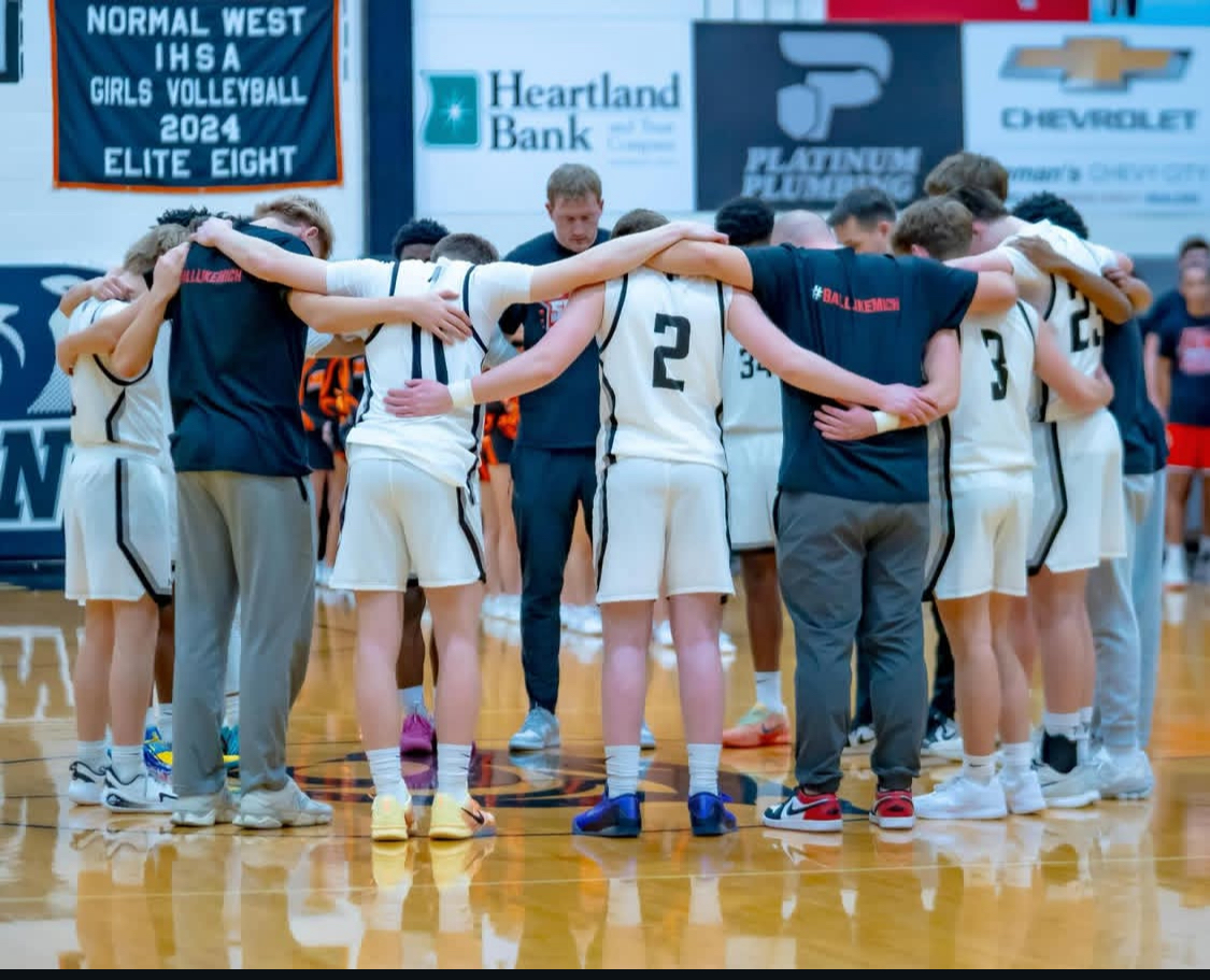 Wildcat boys basketball take on Champaign Centennial in the first round of regionals tonight (Feb 25) at 6 p.m. As they battle it out to keep their season going, they also remember their late assistant coach, D'mitri Dunson-Riggs, who passed away suddenly on Feb. 15. The team honored Dunson-Riggs in their rivalry game against Normal Community on Feb. 20. Above, the team meets at center court prior to tip off.